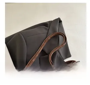 Detail showing the comfortable slim handle of the dark brown leather shoulder bag