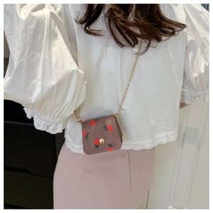 Détail du mini sac bandoulière à motif fraise avec chaîne dorée sur mannequin