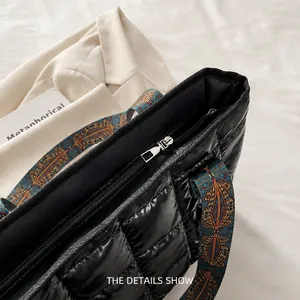 Détail de la fermeture éclair métallique et du tissu matelassé d'un sac noir