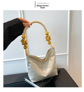 Détail d'un sac en soie beige avec motif d'écran chinois et poignée en perles de bois rétro