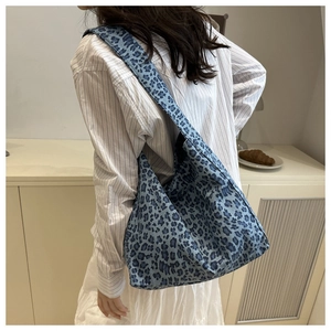 Close-up of a large blue leopard print tote bag showing texture and crescent shape