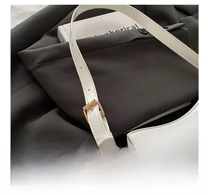 Close-up of adjustable white patent leather shoulder strap with gold-tone buckle hardware