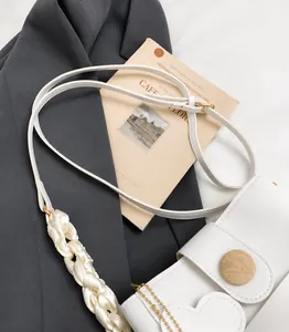 Detail of white lychee leather handbag with silk weave and round wooden buckle