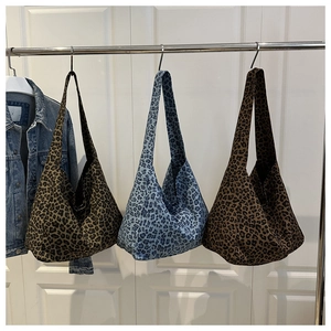 Detailed view of leopard print tote bags in dark coffee, blue and light brown canvas fabric