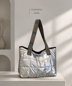 Détail d'un sac cabas argenté matelassé avec bandoulière rétro sur support métallique