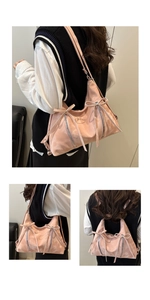Detail der rosa Schultertasche mit Schleifen, glänzendem Faltenstoff und Reißverschlüssen