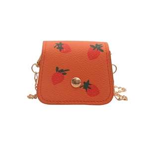 Mini orange crossbody bag with strawberry print and gold chain strap on white background