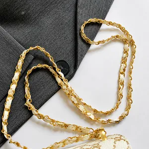 Gros plan de la chaîne en métal doré entrelacée avec un bracelet en cuir à motif