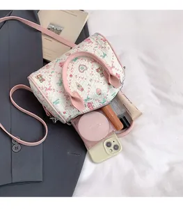 Détail du sac Boston crème avec anses roses montrant l'espace intérieur spacieux