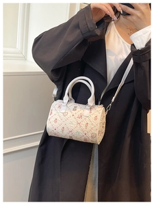 Détail du sac bandoulière blanc avec motifs d'ours roses porté par un mannequin femme