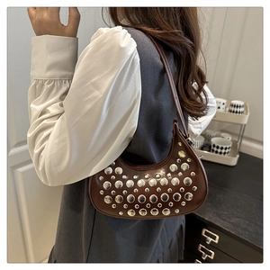 Close-up of a brown hobo shoulder bag with silver metallic studs and leather texture