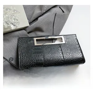 Close-up of black crocodile texture clutch with silver hollow rectangular metal handle