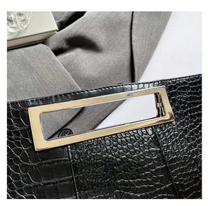 Detail of black crocodile texture handbag with polished silver rectangular metal handle