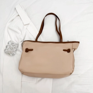 Minimalistische beige canvas tas met bruine contrastbanden en gespdetails