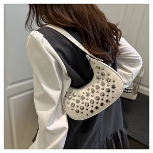 Detailed back view of model wearing white half-moon shoulder bag with silver punk rivets