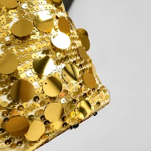 Vue macro du tissu à paillettes dorées avec reflets métalliques sur filet blanc