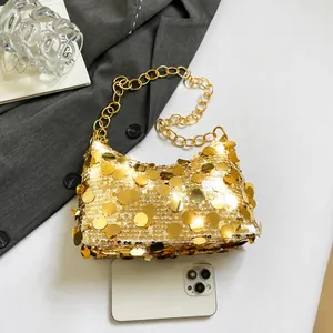 Détail des paillettes dorées sur un sac croissant avec chaîne en métal robuste