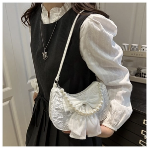 Détail du sac demi-lune en jacquard blanc avec nœud en velours et chaîne en perles