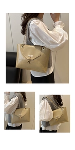 Detail of light khaki shoulder bag featuring golden chain strap and deer charm pendant