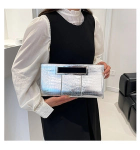 Close-up of silver rectangle clutch bag with crocodile pattern and metal handle