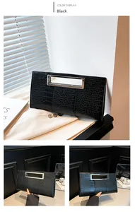 Detail view of black crocodile pattern handbag with rectangular metal cutout handle