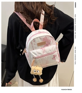 Détail du sac à dos blanc avec calligraphie chinoise, imprimé papillon et porte-clé