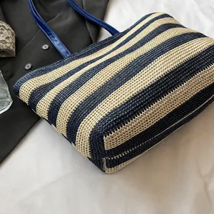 Detail van blauw-beige gestreepte geweven shopper met fijne gaasstructuur en slanke hengsels