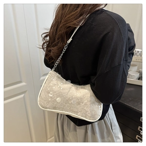 Détail du sac à chaîne à paillettes blanches montrant la texture et la bandoulière argentée