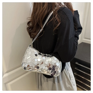 Détail du sac à bandoulière argenté à paillettes avec chaîne et finition métallique