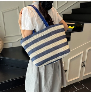 Detail van de blauw-wit gestreepte strooien draagtas met lederen schouderbanden