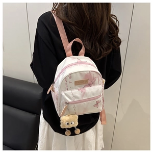 Vue détaillée du mini sac à dos blanc avec papillons et fermetures éclair roses