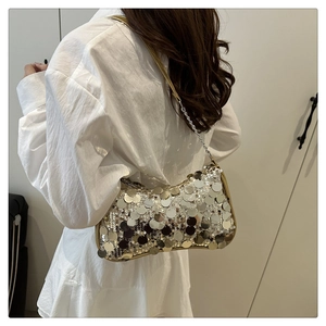 Détail d'un sac à paillettes argentées avec bordure dorée porté par un mannequin