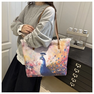 Detail of artistic peacock canvas tote bag featuring stylish frayed edges and leather straps