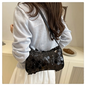 Vue détaillée d'un sac à bandoulière à paillettes noires avec de grandes écailles reflets