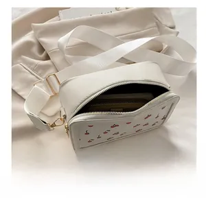 Spacious interior of white cherry print crossbody bag showing fit for a long wallet