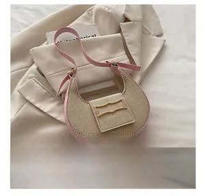 Detalle del bolso de media luna en cuero rosa y paja con hebilla dorada vintage