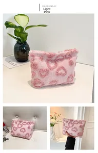 Detail of pink plush toiletry bag with textured heart patterns and zip closure