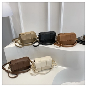 Detail van geweven leren crossbodytassen met golvende randen en kettingen in vijf kleuren