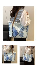 Détail du sac cabas en toile bleue avec imprimé papillon, bords effilés et anses en cuir brun