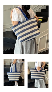 Detail van de grote blauw-wit gestreepte strooien tote bag met blauwe leren handvaten