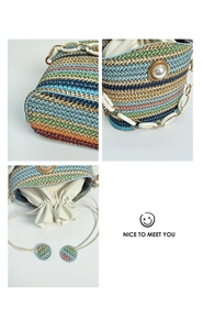 Detail of colorful striped straw bucket bag with large pearl and white acrylic chain