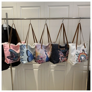 Détail de sacs cabas en toile bohème avec bords effilochés et poignées en cuir