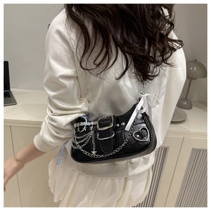 Détail d'un sac bandoulière Y2K noir avec chaînes en métal et ruban blanc décoratif