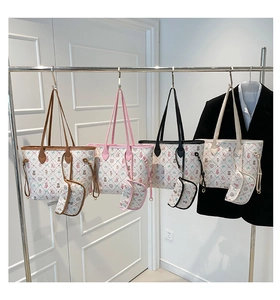 Détail de quatre ensembles de sacs cabas imprimés avec mini-pochettes sur un cintre