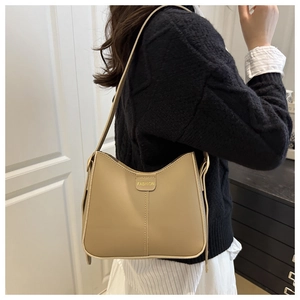 Detail of beige minimalist shoulder bag with vertical stitching and Fashion label detail