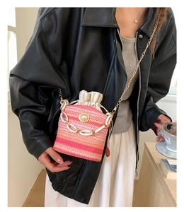 Detail of pink gradient straw mini bucket bag with large pearl and gold chain strap