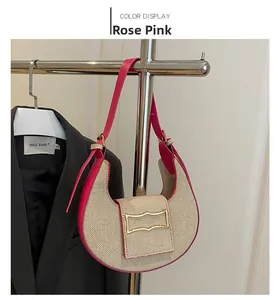 Detalle de bolso medialuna rosa con textura tejida y hebilla de metal dorado