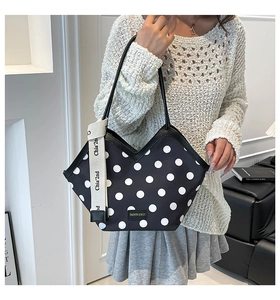 Détail du sac cabas à pois avec bord en V et sangle décorative sur un mannequin