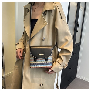 Détail du sac tissé coloré avec rabat en cuir noir et logo doré sur le devant