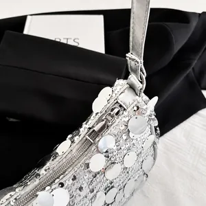 Dettaglio delle paillettes argento e della robusta cerniera in metallo della borsa